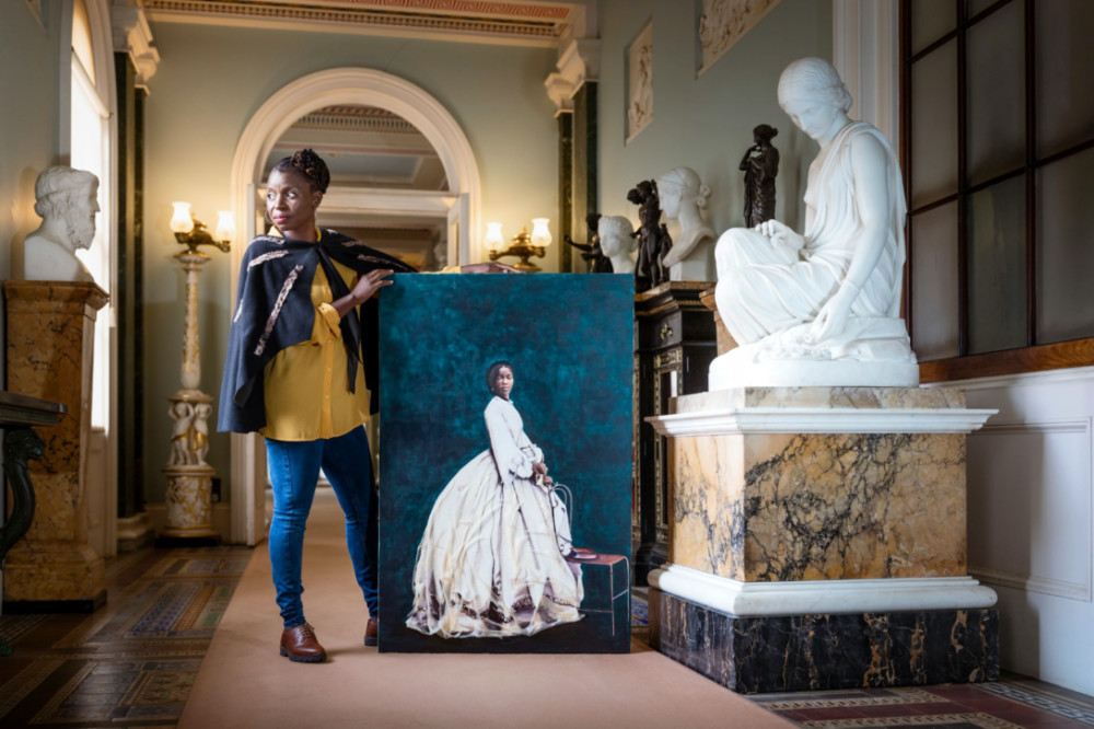 UK Hannah Uzor poses next her portrait of Sarah Forbes Bonetta at Osbourne House