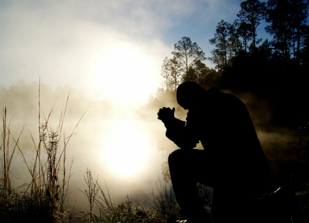 Man praying in forest