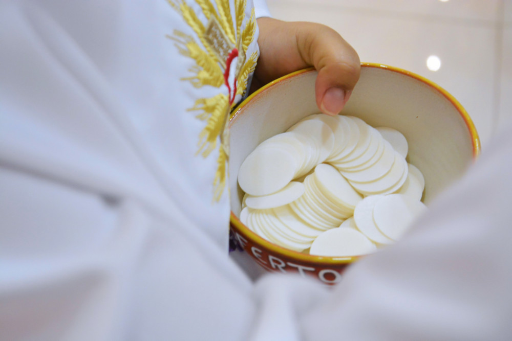 Priest offers Communion wafers