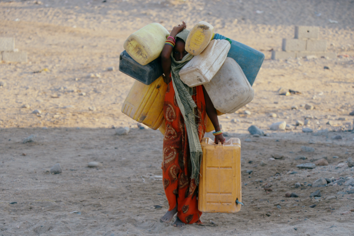 Yemen woman carrying water cans