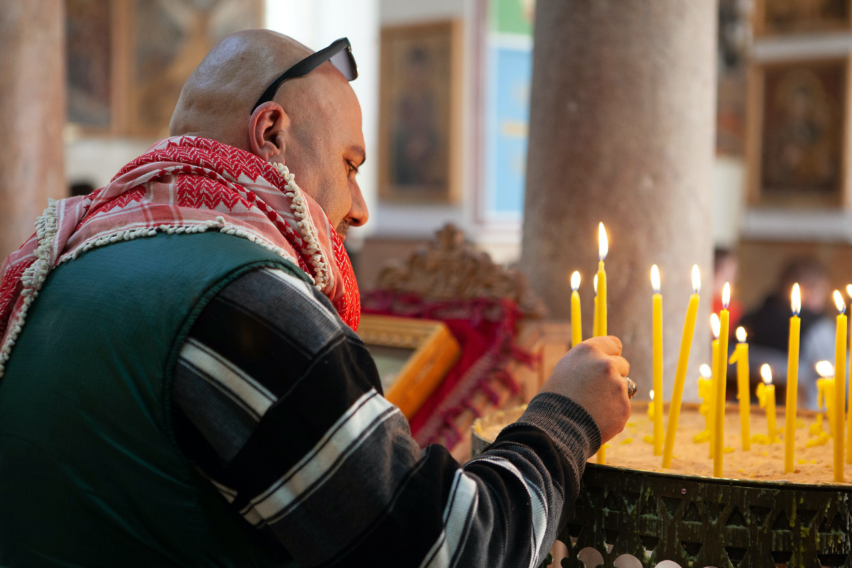 Pilgrim lighting a candle