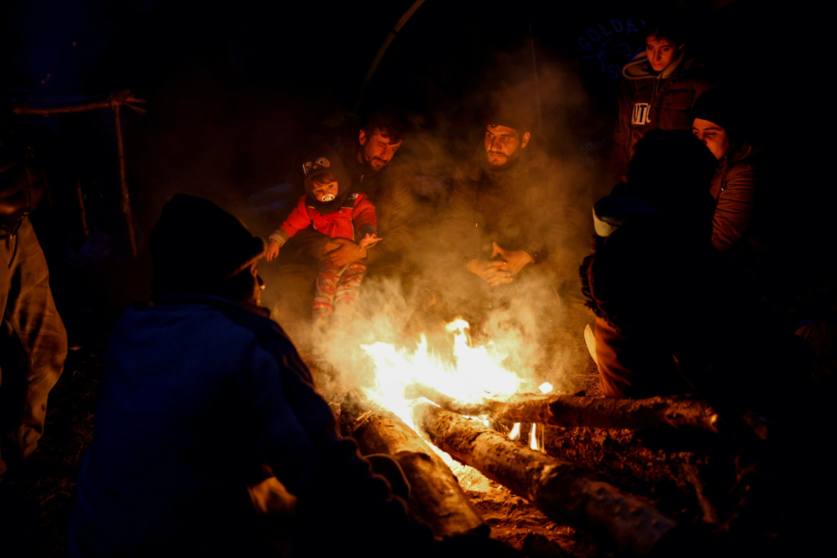 Belarus migrants at campfire