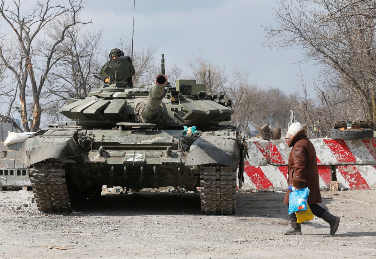 Ukraine Mariupol person and tank