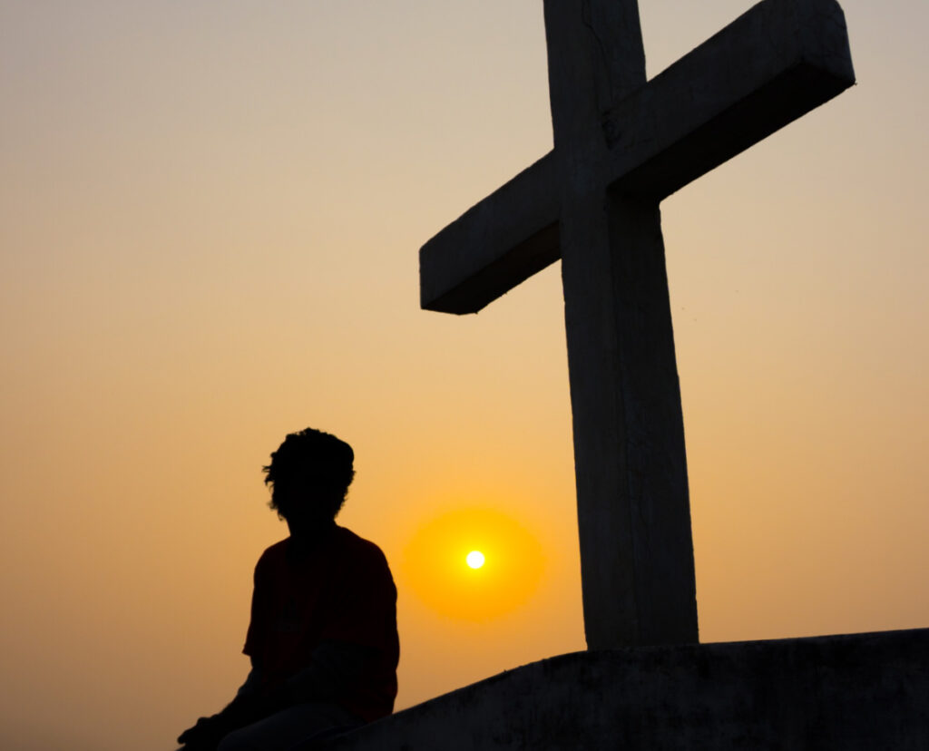 Person sitting under a cross2