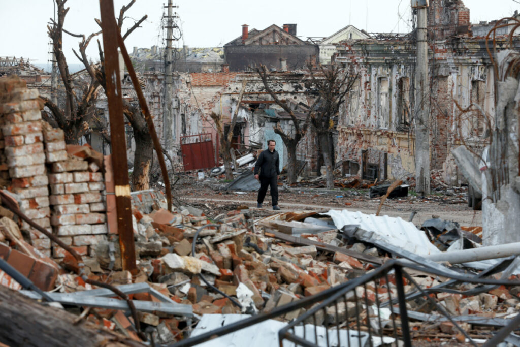 Ukraine Mariupol man walking amid ruins