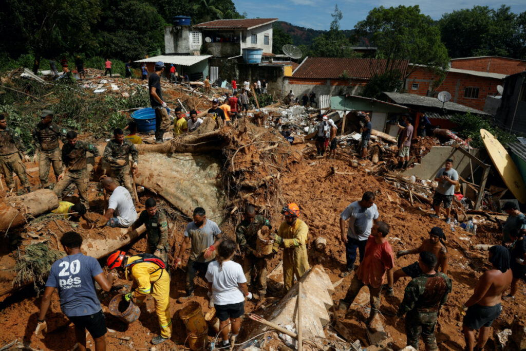 Volunteers and firefighters work to find victims in one of the landslides sites after severe rainfall at Barra do Sahy in Sao Sebastiao, Brazil, February 21, 2023.