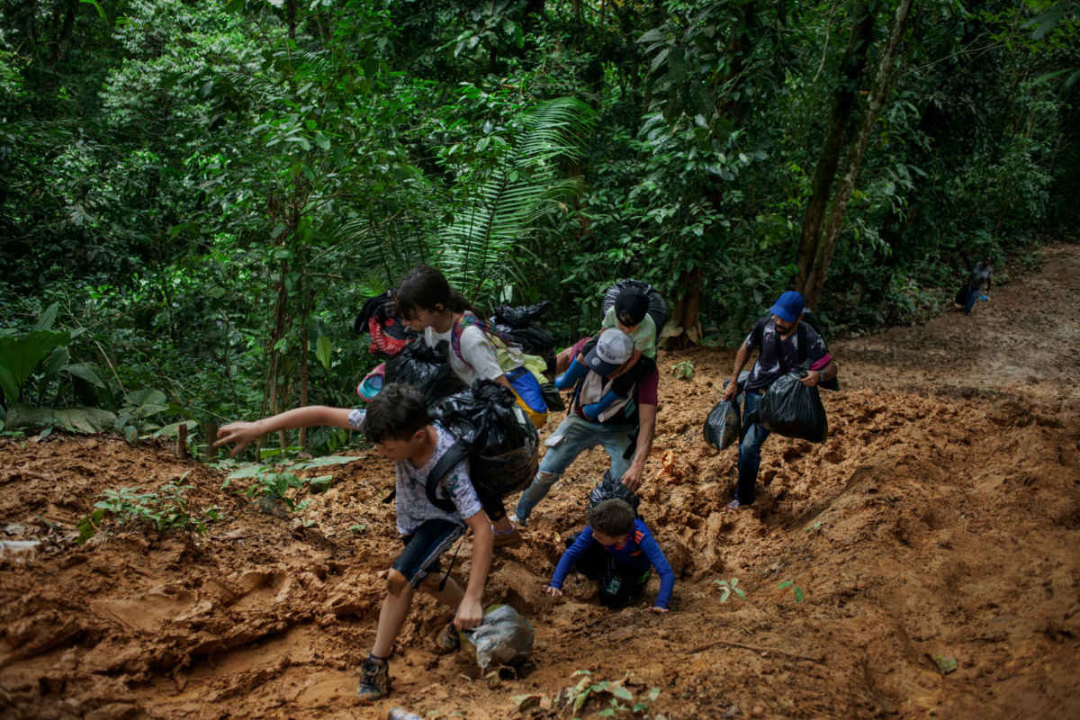 A family of Venezuelan migrants with young children walk through the Colombian jungle in the Darien Gap on day one of a five-to seven-day perilous and exhausting trek through the Darien Gap, Colombia, July 27, 2022. Thomson Reuters Foundation/Fabio Cuttica