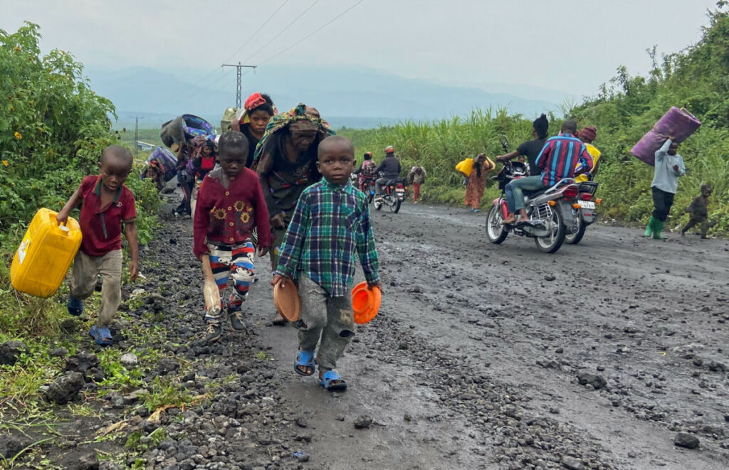 Civilians carry their belongings as they flee after heavy gunfire that raised fears of M23 rebels advancing along a road from Sake near Goma in the North Kivu province of the Democratic Republic of Congo February 9, 2023.
