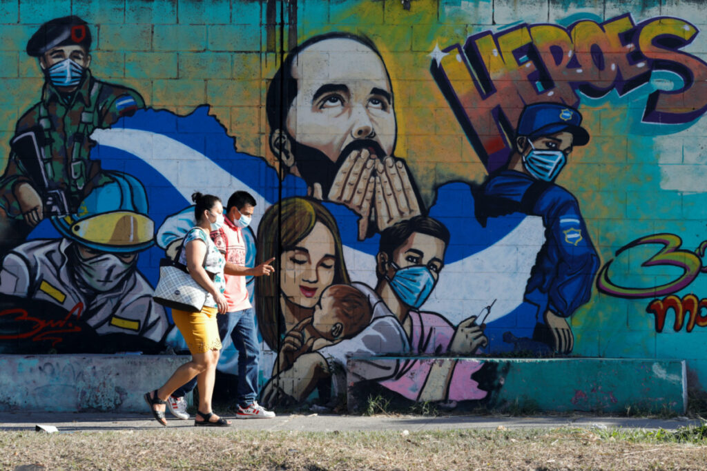 People walk by a graffiti depicting El Salvador's President Nayib Bukele in Soyapango, El Salvador January 25, 2023. REUTERS/Jose Cabezas
