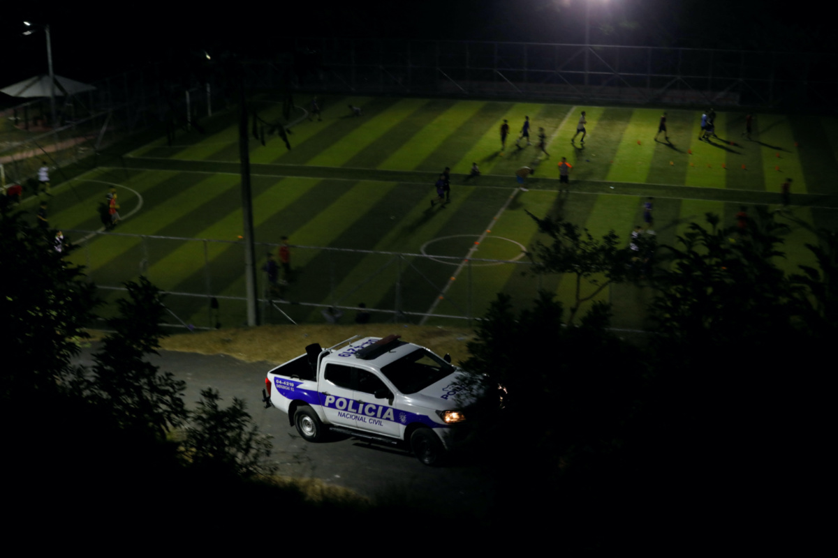 A patrol car passes by the soccer field at La Campanera neighborhood, in Soyapango, El Salvador February 6, 2023. REUTERS/Jose Cabezas