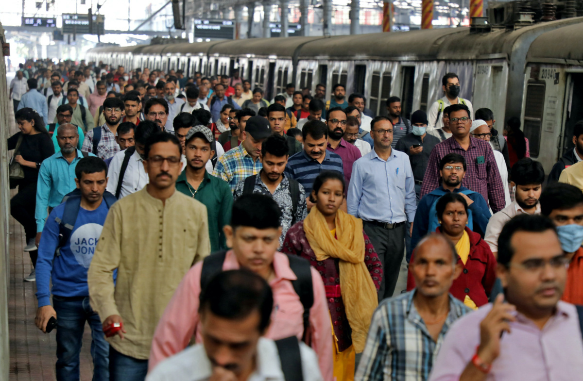 Commuters walk on a platform after disembarking from a suburban train at a railway station in Mumbai, India, January 21, 2023.
