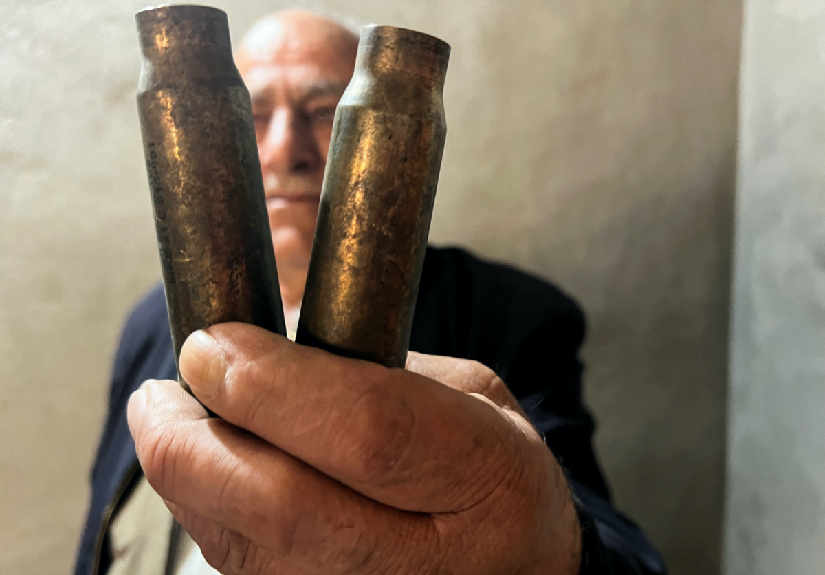 Haider Mohamed Khaled displays shell casings, he said he found in his house in Sararo village, following Turkish bombardments last spring on the area, in Dohuk, Iraq, December 27, 2022. REUTERS/Amina Ismail