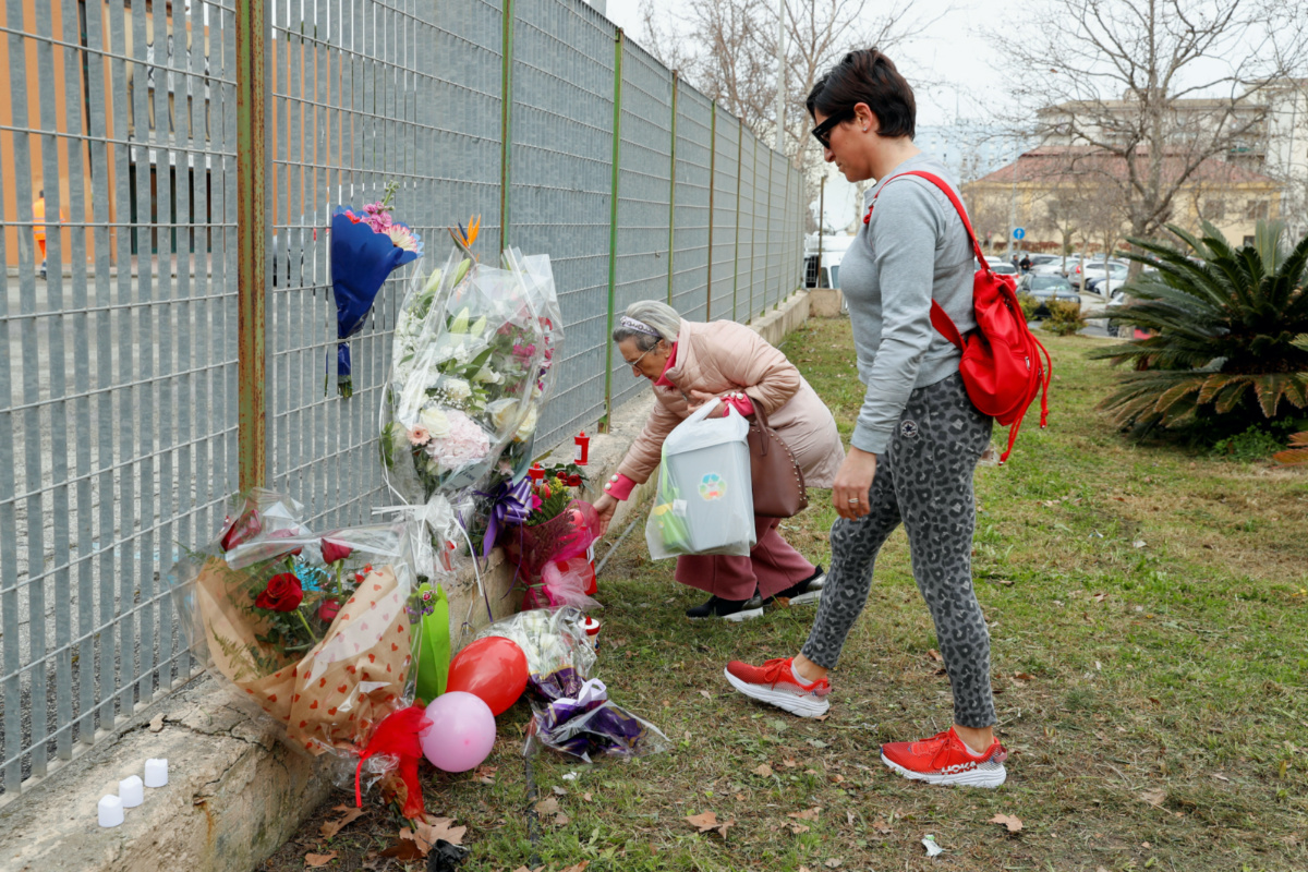 People lay tributes outside PalaMilone sports hall, where victims' coffins are kept in the aftermath of a deadly migrant shipwreck, in Crotone, Italy, February 27, 2023. REUTERS/Remo Casilli