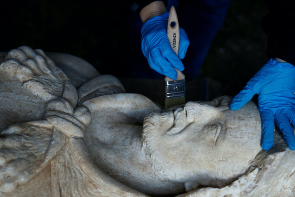 Restorer from Appia Antica archaeological park Sara Iovine cleans a life-sized statue of a Roman emperor posing as the classical hero Hercules after it was discovered during sewer repair works near the old Appian Way, ancient Rome's first highway, in Rome, Italy, February 1, 2023. REUTERS/Guglielmo Mangiapane