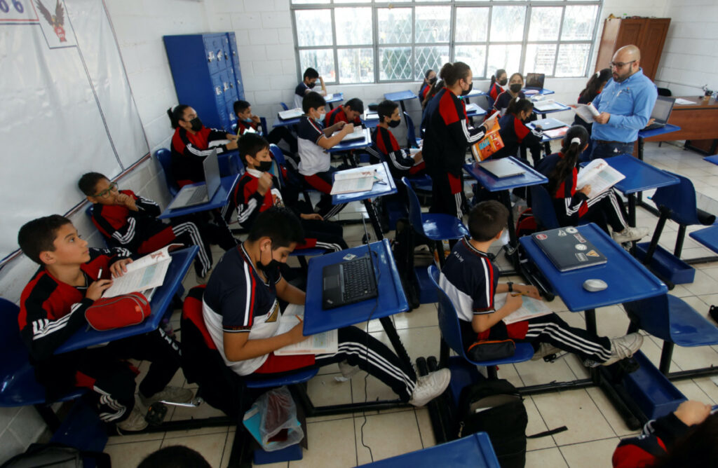 FILE PHOTO: High school students pedal on a bike desk, as part of a program to improve physical health and increase concentration during classes, in San Nicolas de los Garza, Mexico January 30, 2023. REUTERS/Daniel Becerril