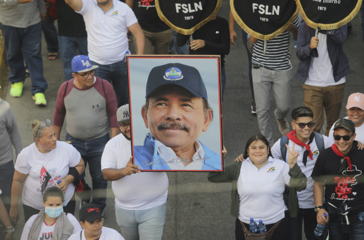 A man marches holding a portrait of President Daniel Ortega during a pro-government march in Managua, Nicaragua, Saturday, Feb 11, 2023.