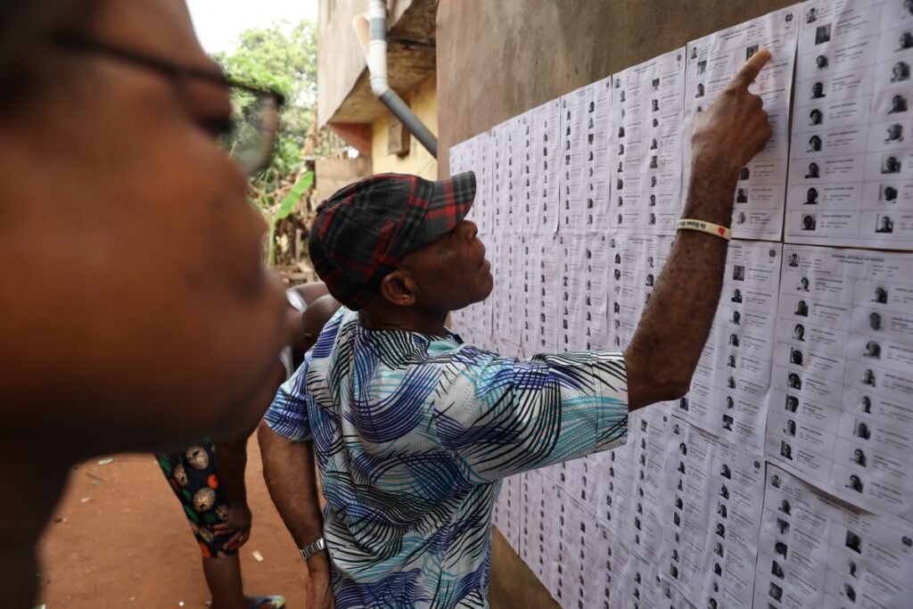 People looks for their names on voters list put up on a wall at a polling unit, during Nigeria's Presidential election in Agulu, Anambra state, Nigeria February 25, 2023.
