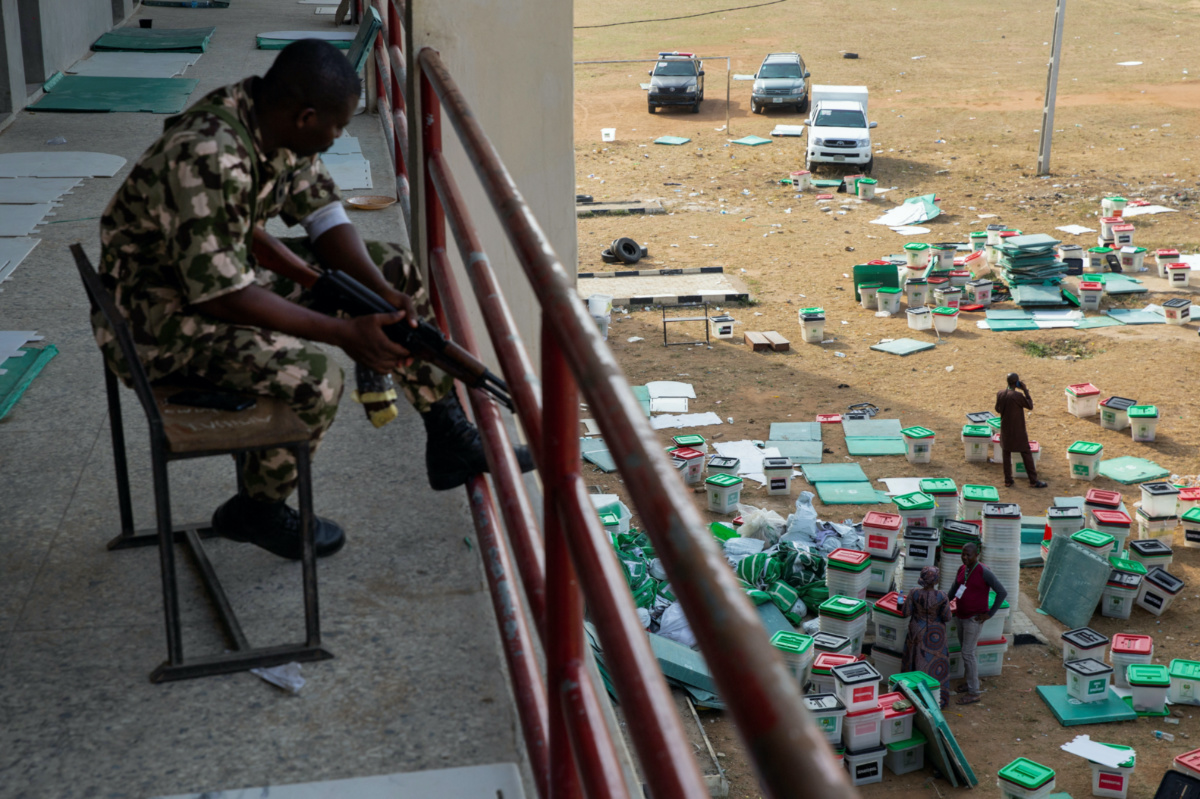 A day after the elections, a soldier guards a vote collation centre that had been stormed by unknown assailants earlier in the day in Alimosho, Lagos, Nigeria on February 26, 2023. 