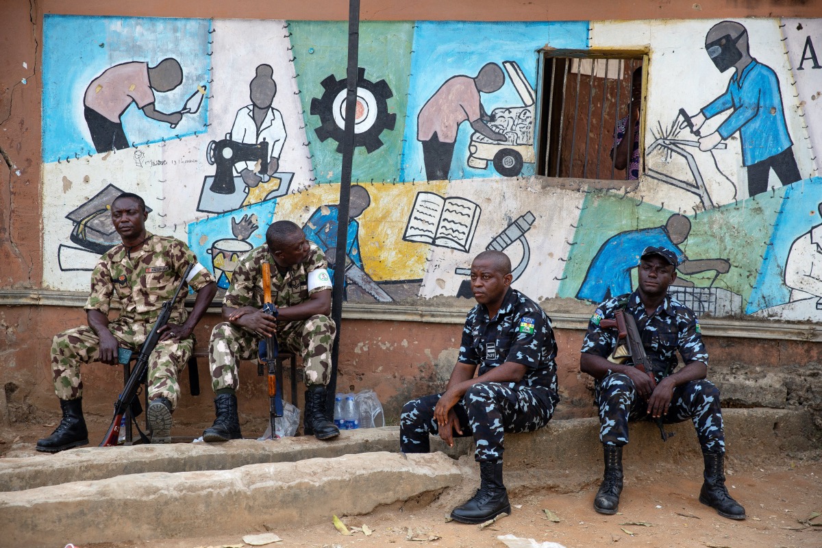 A day after the elections, soldiers and police guard the entrance to a vote collation centre that had been stormed earlier in the day by unknown assailants, some of who were apprehended in Alimosho, Lagos, Nigeria on February 26, 2023.