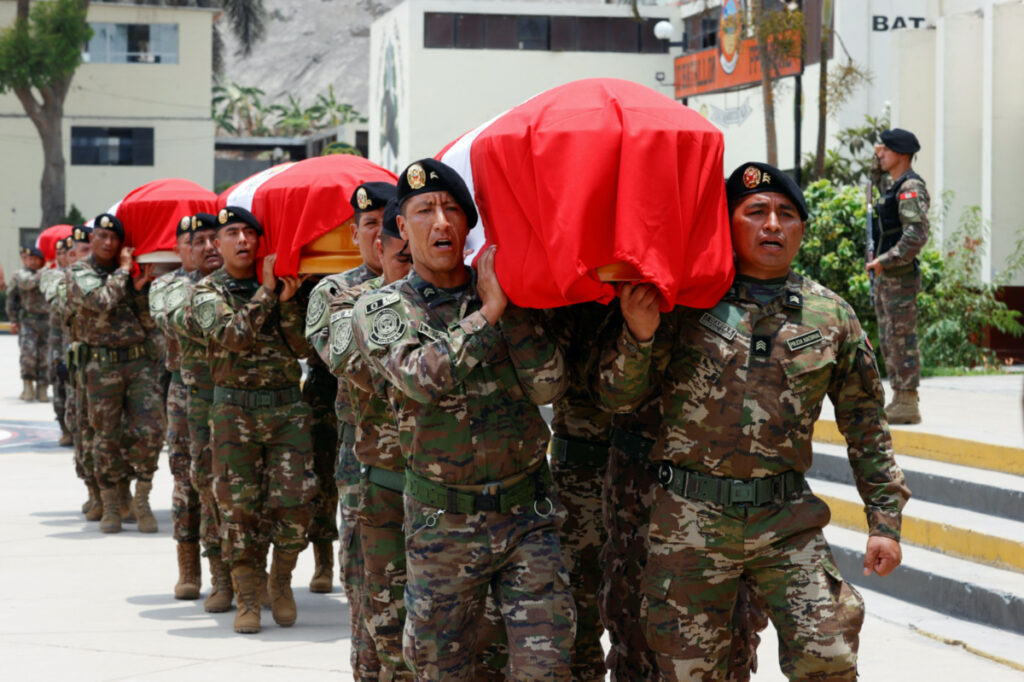Police officers carry flag-draped coffins during a ceremony to honor their seven fellow troopers gunned down during an ambush last Saturday, in Lima, Peru February 13, 2023.