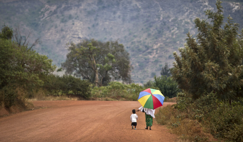 FILE - A mother reaches out to hold the hand of her young daughter, as they walk home after a church service in the village of Rwinkwavu, near to Akagera National Park, in Rwanda on Sept. 6, 2015. The Protestant Council of Rwanda in Feb. 2023 has directed all health facilities run by its members to stop carrying out all abortions, further limiting access to the procedure in the largely Christian nation of 13 million people. (AP Photo/Ben Curtis, File)