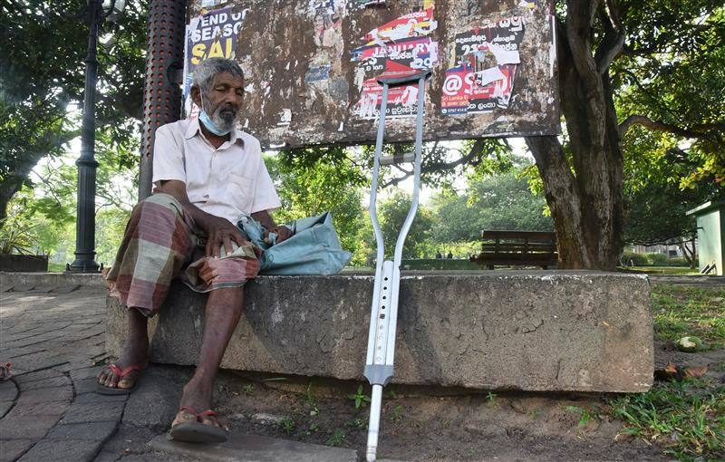 Senior citizen Kiri Banda rests at a public park after walking around and begging for change in Colombo, Sri Lanka on January 30, 2023.