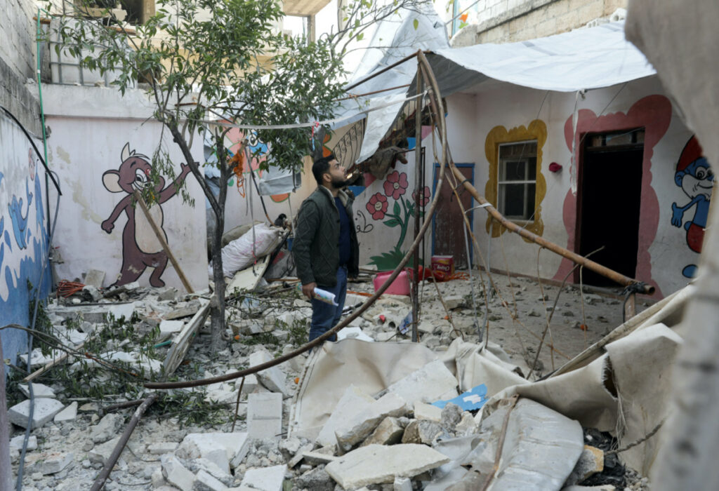 Ramadan al-Suleiman stands on rubble from the damaged Kawkab al-Tofoula nursery, of which he is the manager, in the aftermath of an earthquake, in rebel-held town of Jandaris, Syria February 12, 2023.