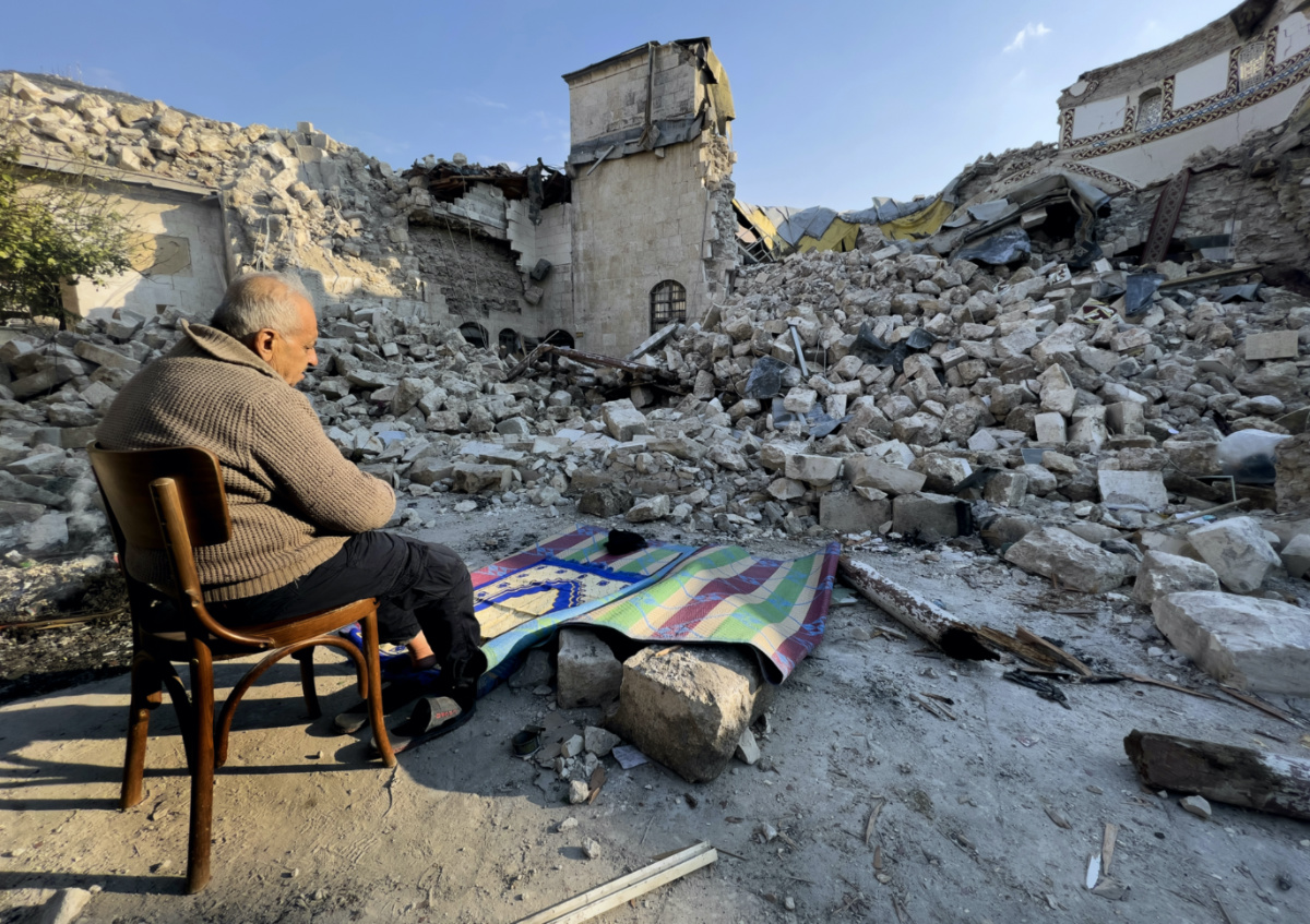 Turkish citizen Mehmet Ismet prays in front the rubble of the historic Habib Najjar mosque which destroyed during the devastated earthquake, in the old city of Antakya, Turkey, Saturday, Feb. 11, 2023.