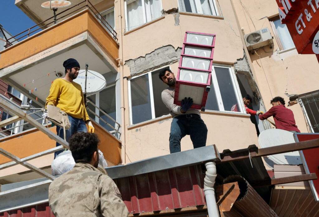 People take their belongings from their apartments in the aftermath of a deadly earthquake in Antakya, Turkey February 16, 2023.