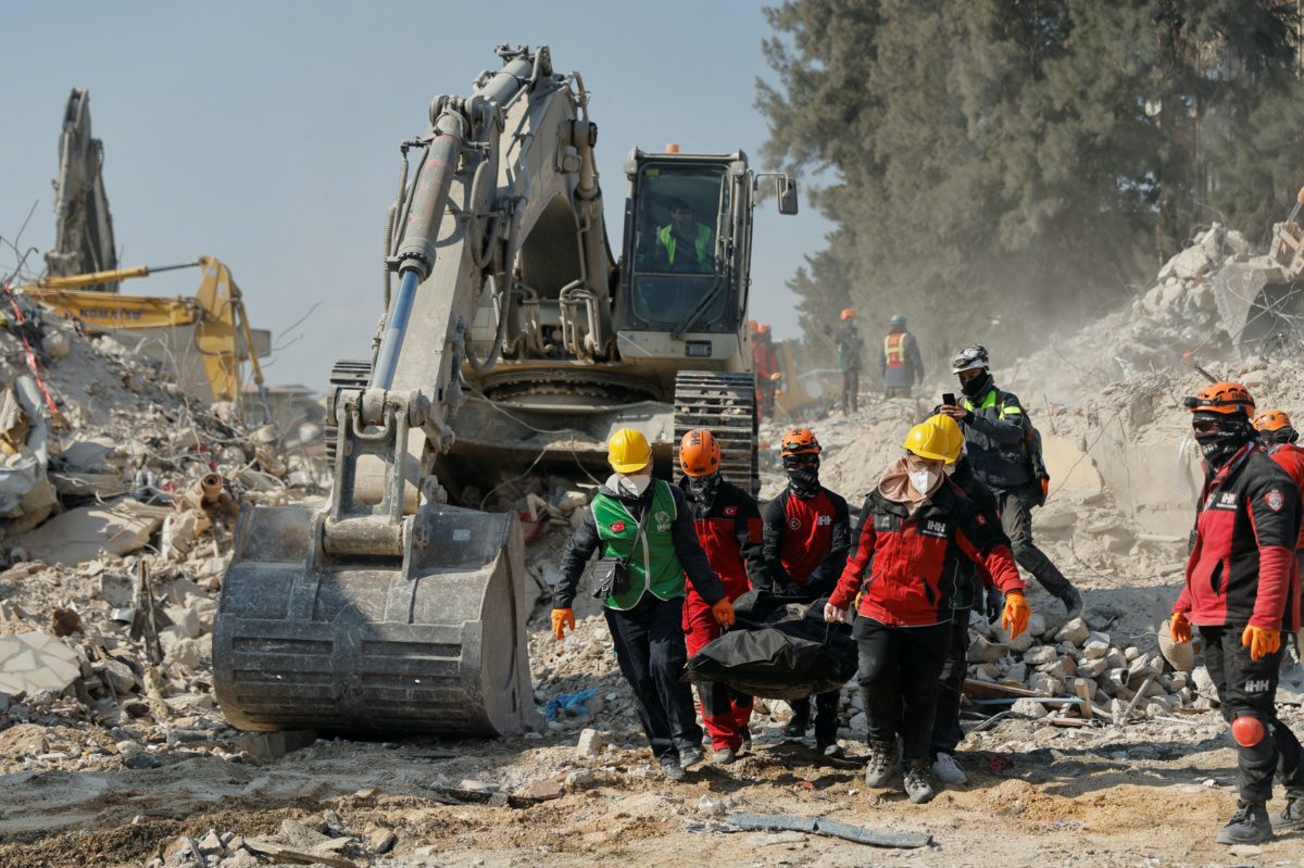 Rescuers carry the body of a victim at the site of a collapsed building, in the aftermath of the deadly earthquake, in Antakya, Turkey February 18, 2023. 