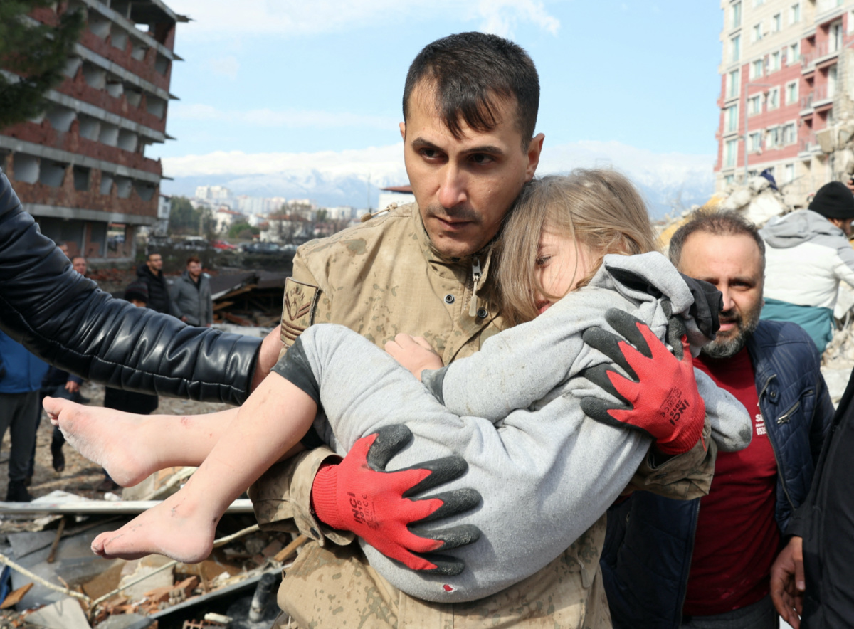 Muhammet Ruzgar, 5, is carried out by a rescuer from the site of a damaged building, following an earthquake in Hatay, Turkey, on 7th February, 2023.