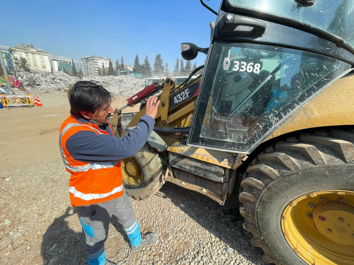 Akin Bozkurt operates a bulldozer at the site of collapsed buildings, taking part in the efforts to find bodies under rubble, in the aftermath of the deadly earthquake, in Kahramanmaras, Turkey, February 18 2023.