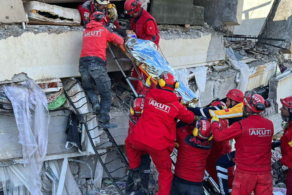 Rescuers carry a woman after she was evacuated from under a collapsed building following an earthquake in Kahramanmaras, Turkey, on 7th February, 2023