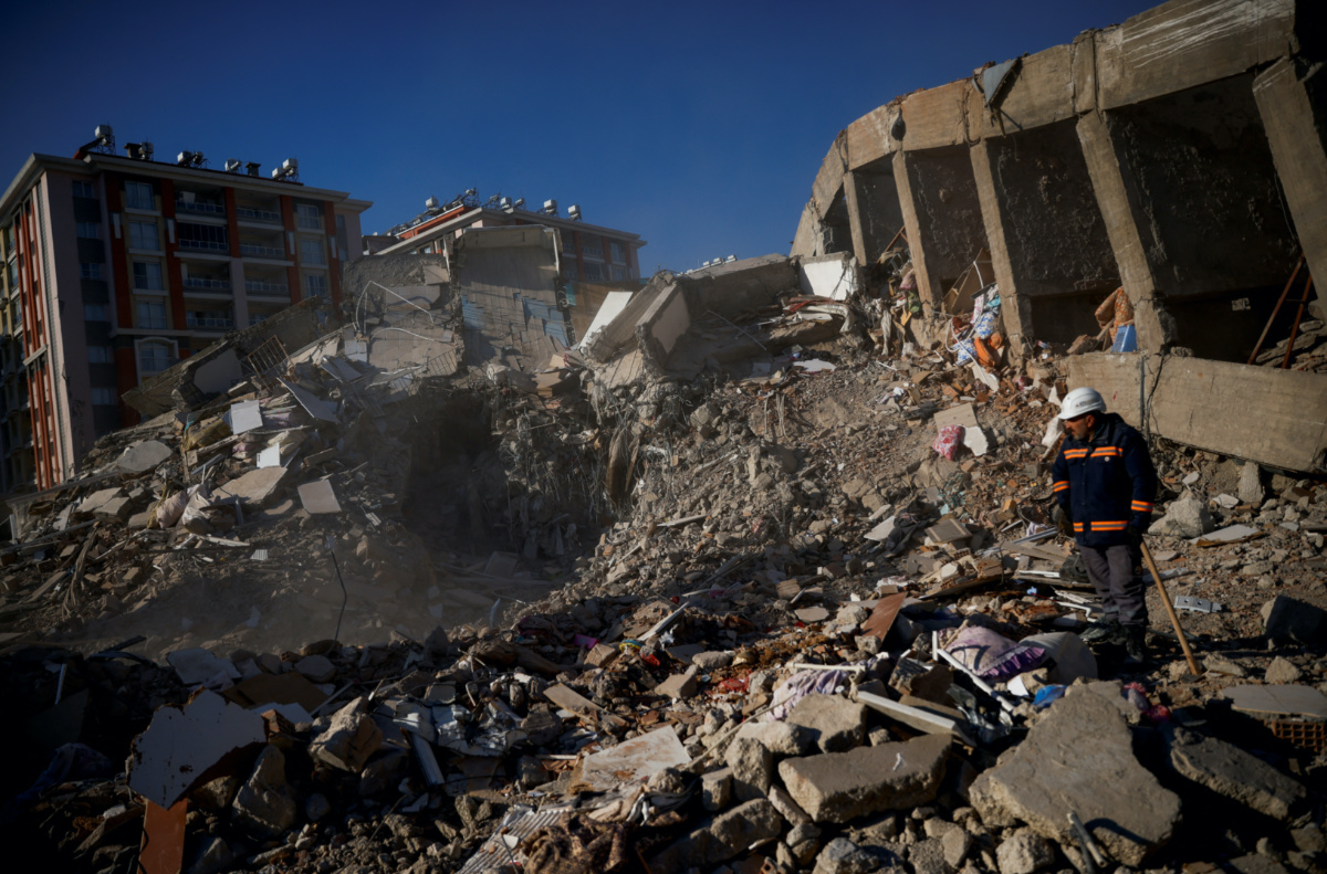 A person stands amidst rubble in the aftermath of a deadly earthquake in Kirikhan, Turkey February 9, 2023.
