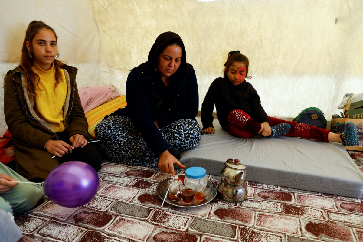 Neslihan Altinbas drinks tea in a tent, which serves as a camp for survivors, in the aftermath of the deadly earthquake in Osmaniye, Turkey February 16, 2023. 