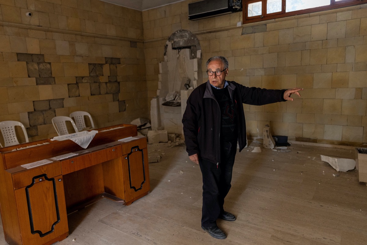 Mishak Hergel points to the damaged altar at the church in Vakifli, the last Armenian village in Turkey, in the aftermath of the deadly earthquake in Samandag, Turkey, February 24, 2023. REUTERS/Eloisa Lopez
