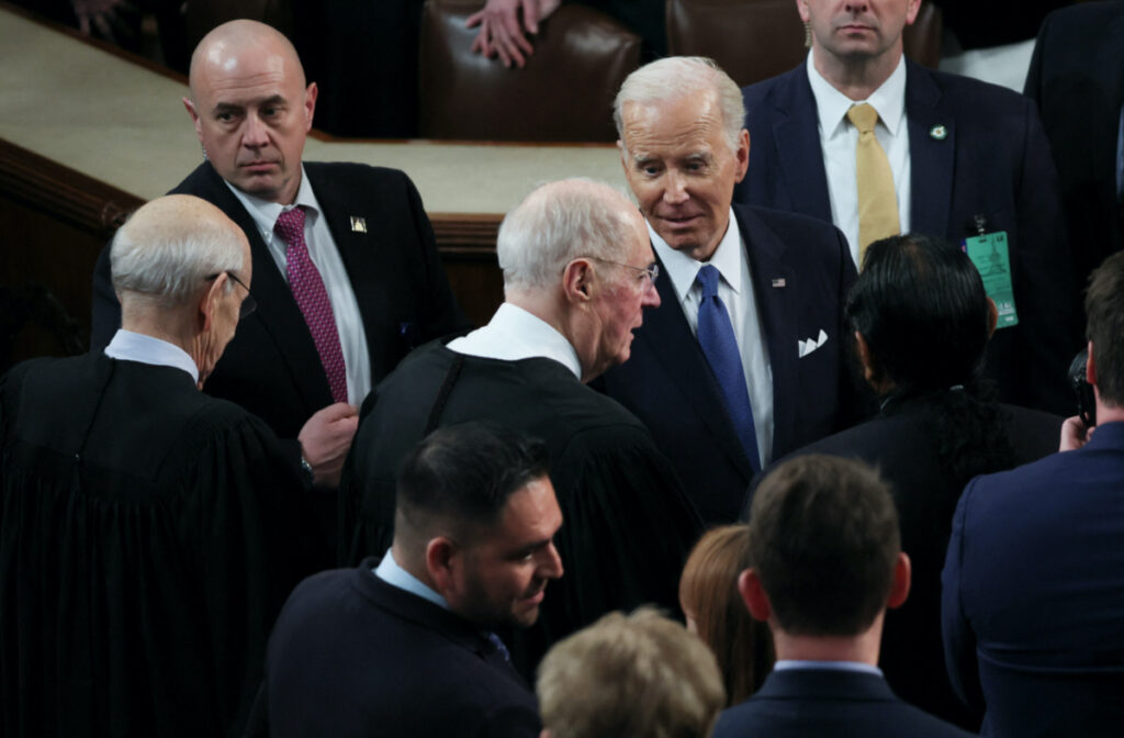 U.S. President Joe Biden talks with retired Supreme Court Justices Stephen Breyer and Anthony Kennedy as he departs after concluding his State of the Union address before a joint session of Congress in the House Chamber at the U.S. Capitol in Washington, U.S., February 7, 2023. REUTERS/Leah Millis