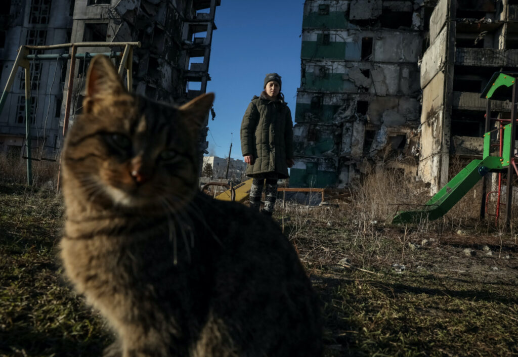 Veronika Krasevych, an 11-year-old Ukrainian girl stands next to a cat near her building destroyed by Russian military strike in the town of Borodianka heavily damaged during Russia's invasion of Ukraine, outside of Kyiv, Ukraine February 15, 2023.