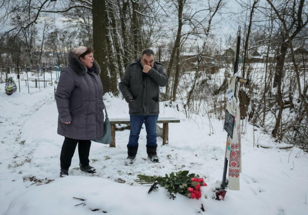Svitlana Safonova, 60, visit the grave of her sister Iryna Filkina, 52, along with Iryna's partner Anatoliy Shchyruk in Bucha, outside of Kyiv, Ukraine February 7, 2023. REUTERS/Gleb Garanich
