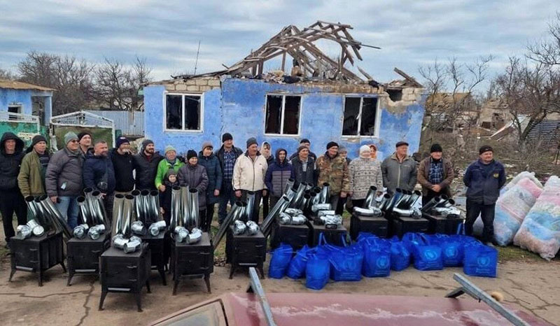 Ken Ward and volunteers pose together before distributing blankets and wood-burning stoves in Ukraine. 