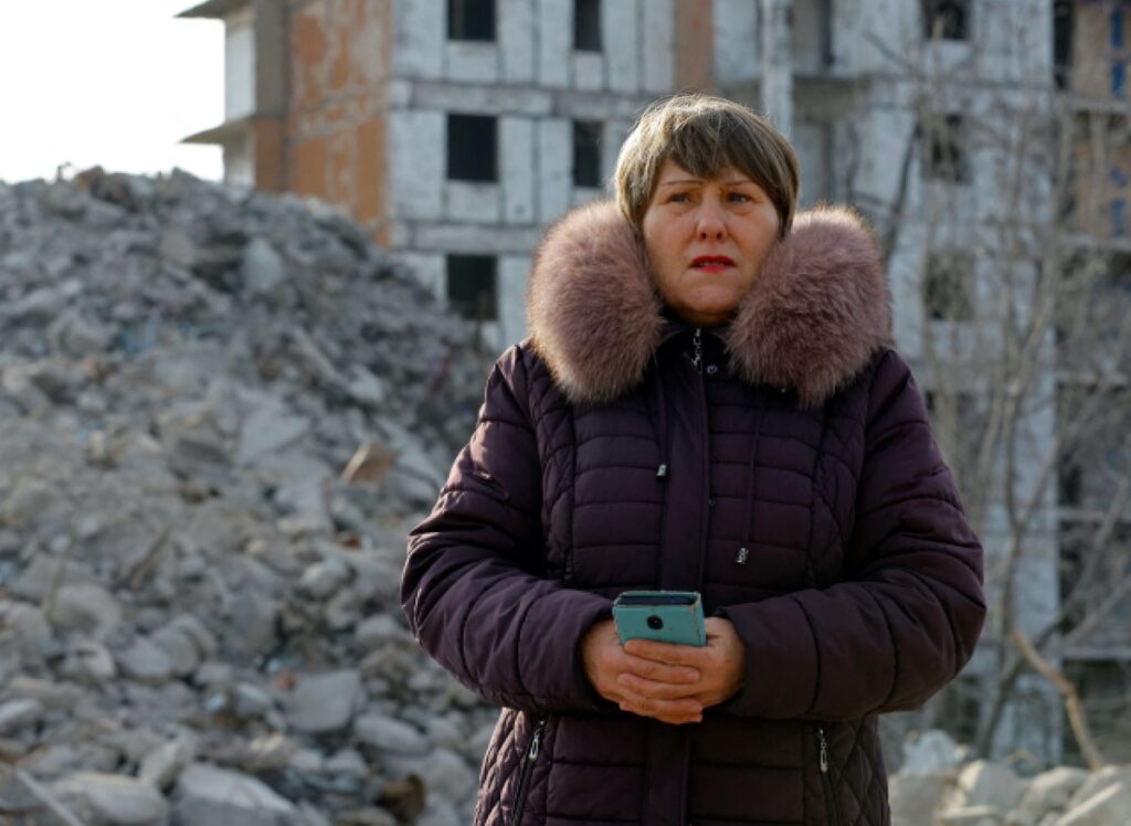 Tatiana Bushlanova, 65, stands next to the ruins of her apartment block, demolished due to heavy damage received in the course of Russia-Ukraine conflict in Mariupol, Russian-controlled Ukraine, February 5, 2023. REUTERS/Alexander Ermochenko