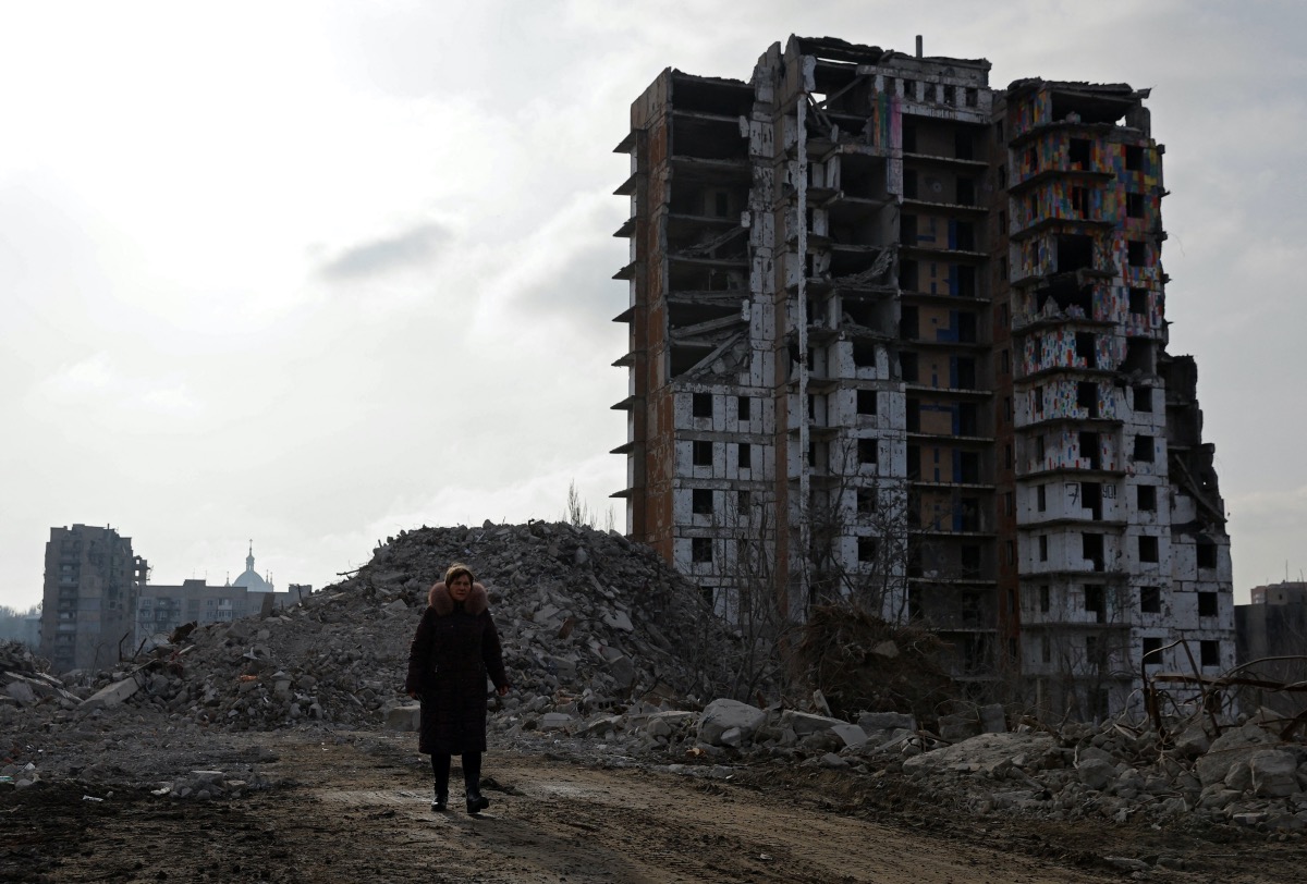 Tatiana Bushlanova, 65, walks next to the ruins of her apartment block, demolished due to heavy damage received in the course of Russia-Ukraine conflict in Mariupol, Russian-controlled Ukraine, February 5, 2023. 