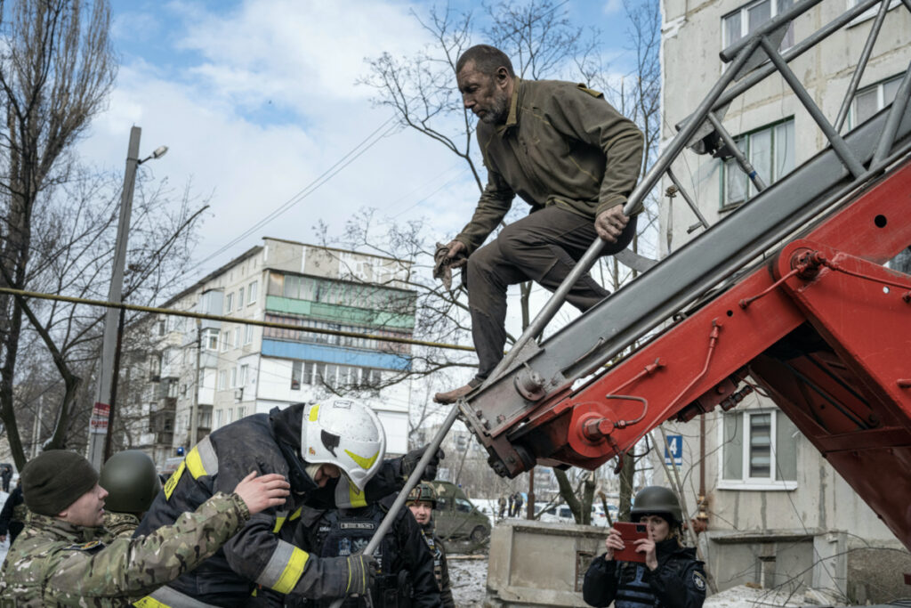 A man is rescued by firefighters after an apartment block was heavily damaged by a missile strike, amid Russia's attack on Ukraine, in Pokrovsk, Donetsk region, Ukraine, February 15, 2023. REUTERS/Marko Djurica