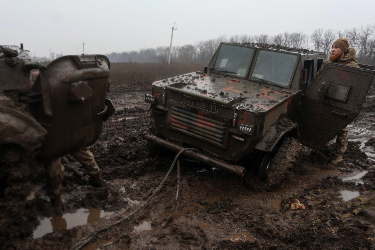 Ukrainian service members are seen next to armoured vehicles near the frontline town of Bakhmut, amid Russia's attack on Ukraine, in Donetsk region, Ukraine February 25, 2023. 