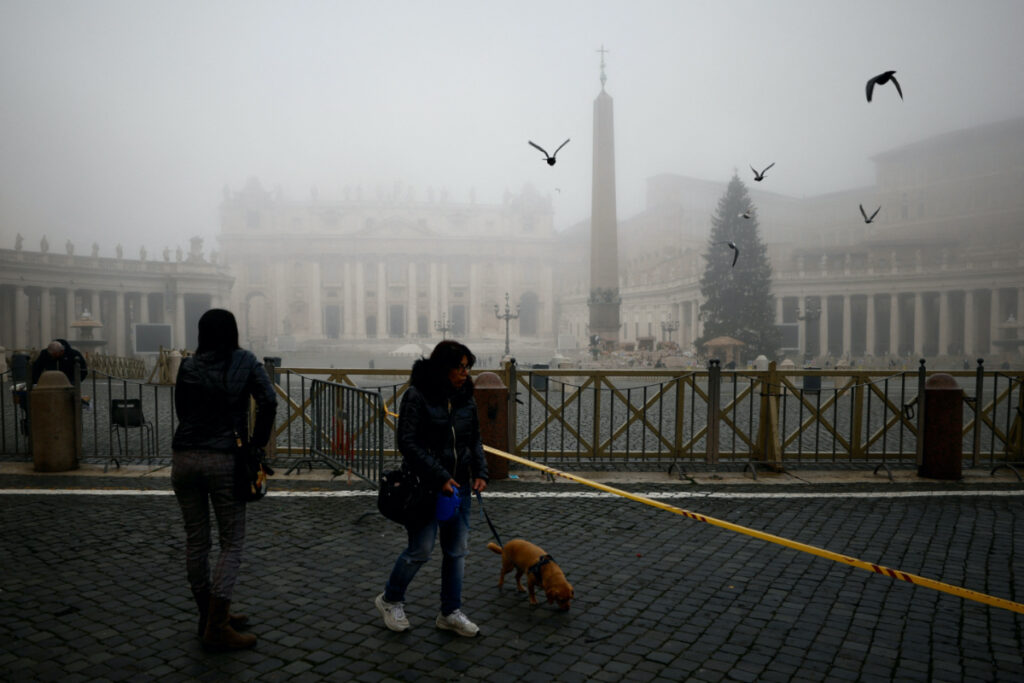 People walk near St. Peter's Square on a foggy day ahead of the mass to be celebrated by Pope Francis to mark the World Day of Peace in St. Peter's Basilica at the Vatican, January 1, 2022.