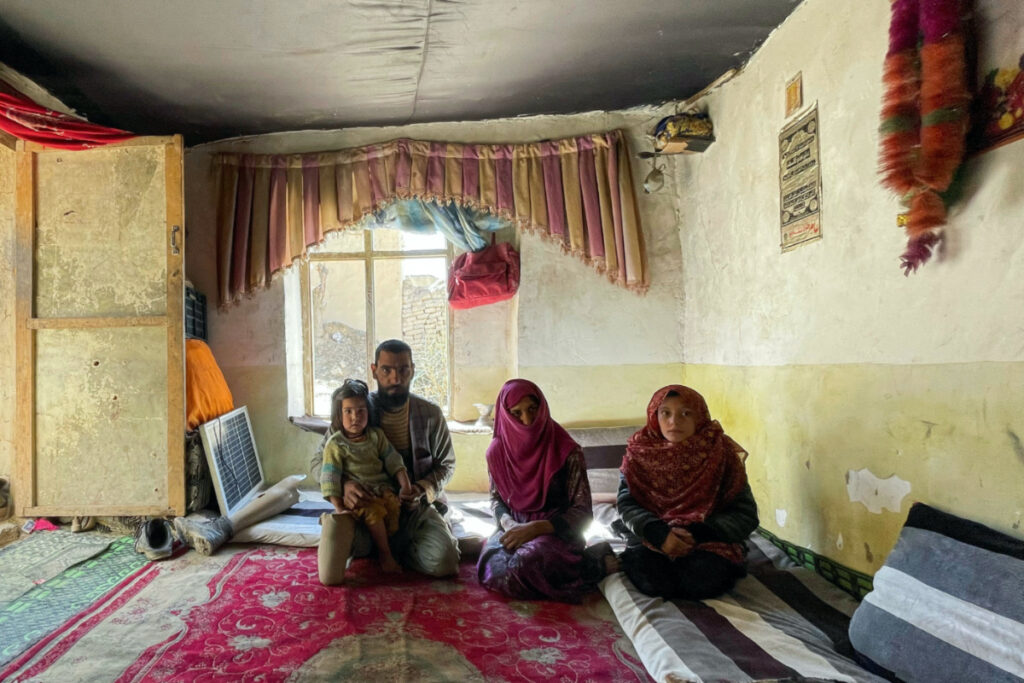 The family of Khair Mohammad, who has lost his legs due to mine explosion, poses for a photograph in their house in Kabul, Afghanistan, March 19, 2023. REUTERS/Sayed Hassib