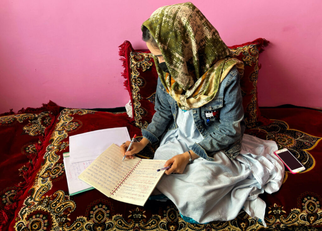 FILE PHOTO: Sofia, an Afghan student, takes notes during an online class, at her house in Kabul, Afghanistan, March 18, 2023. REUTERS/Sayed Hassib