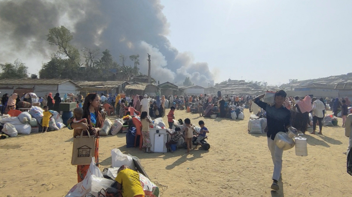 People flee with their belongings as the fire in Cox's Bazar refugee camp continues, Bangladesh March 5, 2023 in this still image obtained by REUTERS from a video