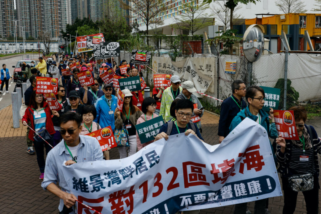 Protesters are required to wear numbered lanyards around their necks as they protest against a land reclamation and waste transfer station project during one of the first demonstrations to be formally approved since the enactment of a sweeping national security law, in Hong Kong, China March 26, 2023. REUTERS/Tyrone Siu