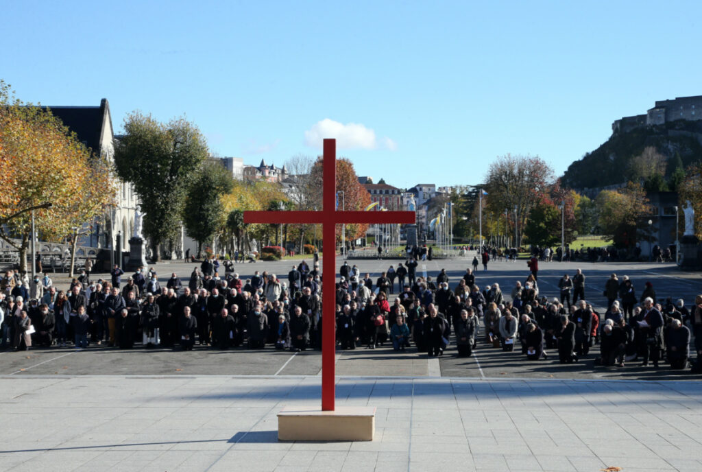 Bishops kneel on the forecourt of the Notre-Dame-du-Rosaire basilica in the sanctuary of Lourdes, southwestern France, Saturday, Nov. 6, 2021 during a ceremony, part of The Bishops' Conference.
